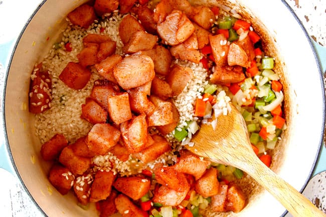 showing how to make chicken and rice recipe by cooking sauteing chicken with rice, carrots, onions and celery