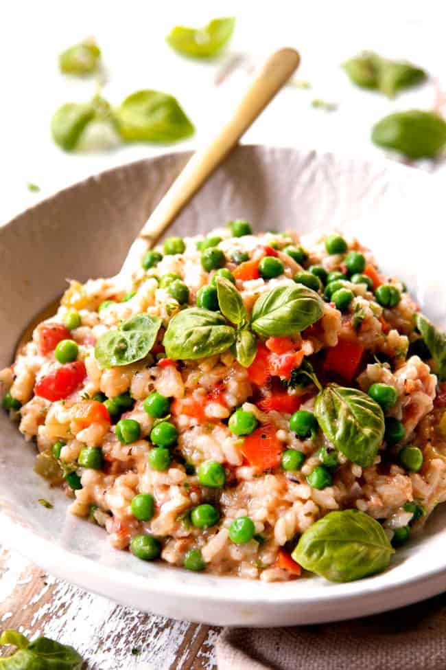 a small white bowl of chicken and rice recipe with a golden spoon ready to eat
