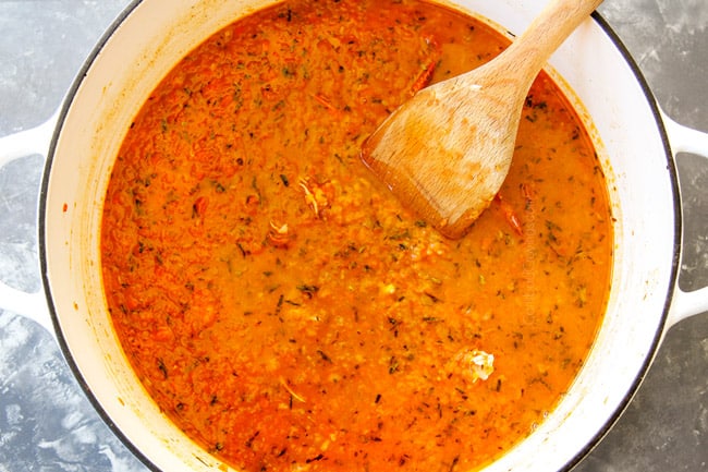 showing how to make lobster bisque by adding clam juice or fish stock and simmering