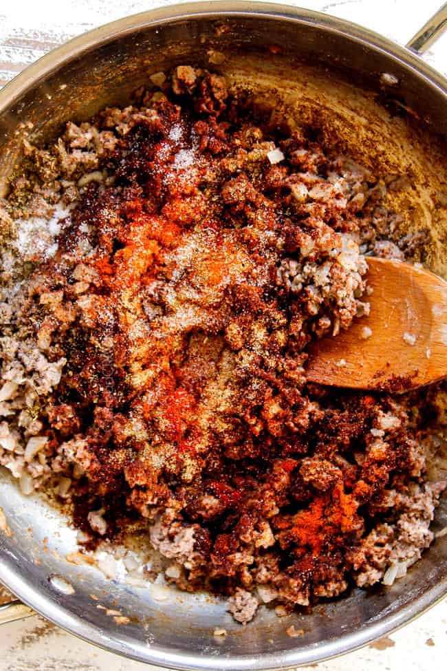 showing how to make Mexican Lasagna recipe by cooking ground beef in a large skillet until browned then adding chili powder, ground cumin, smoked paprika
