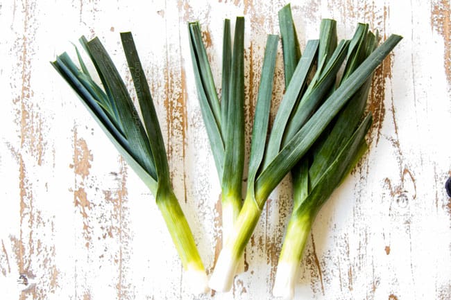showing how to make potato leek soup by spreading leeks on a cutting board