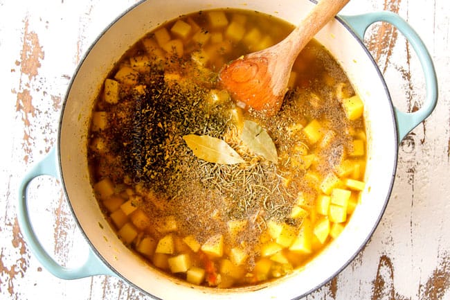 showing how to make potato leek soup by adding chicken broth and seasonings to soup then brining to a simmer