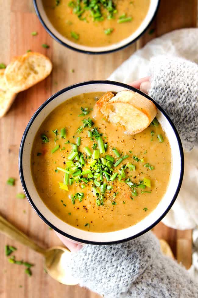 two hand holding a bowl of creamy Potato Leek Soup recipe