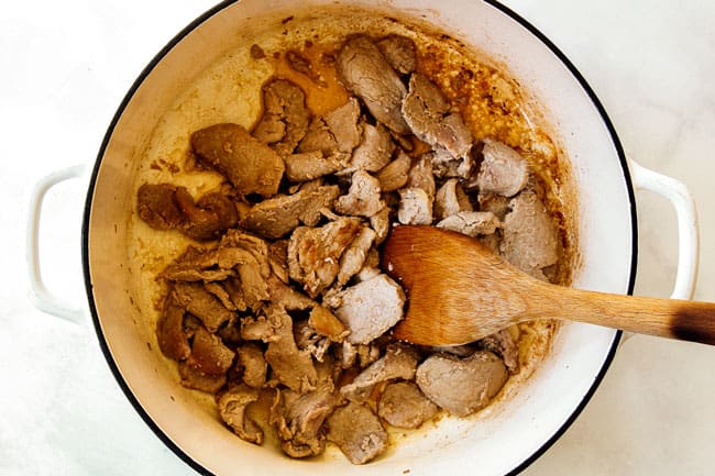 showing how to make ramen recipe by cooking pork in a large Dutch oven