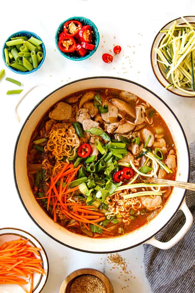 showing how to make ramen recipe by adding bok choy and green onions to soup