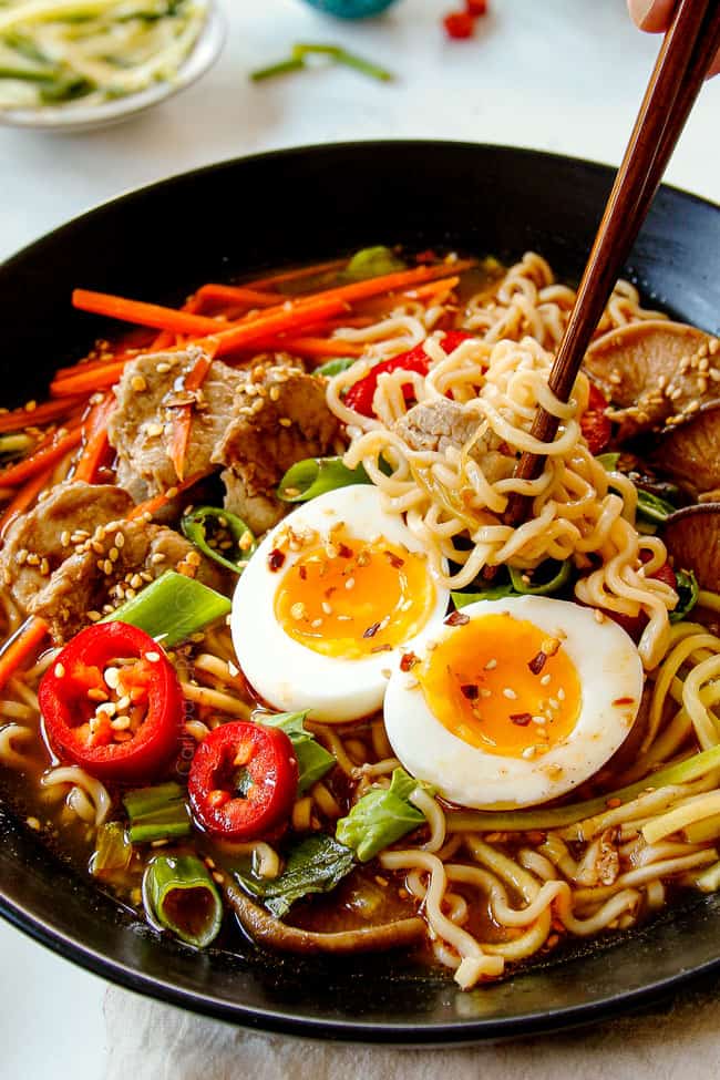 showing how to eat ramen by garnishing with sesame seeds and gochujang