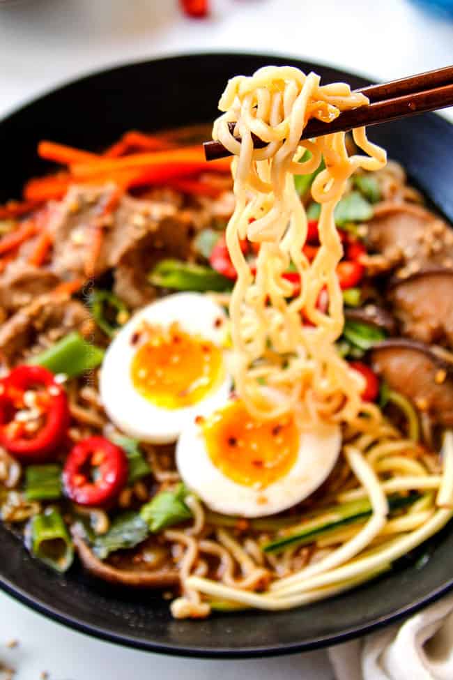showing how to eat shoyu ramen by by picking up ramen noodles with chopsticks
