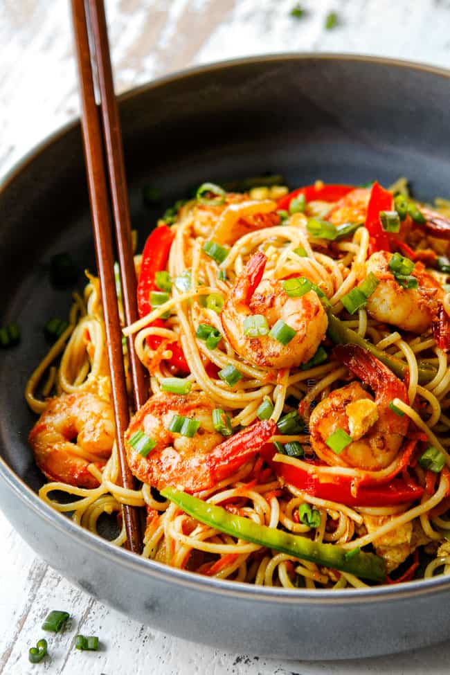 showing how to eat Singapore Rice Noodles by using chopsticks to pick up noodles