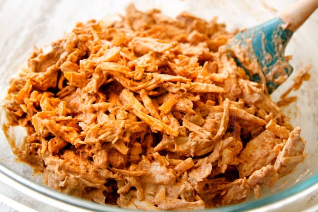 showing how to make easy chicken enchiladas by stirring gall of the filling ingredients together in a glass bowl until combined