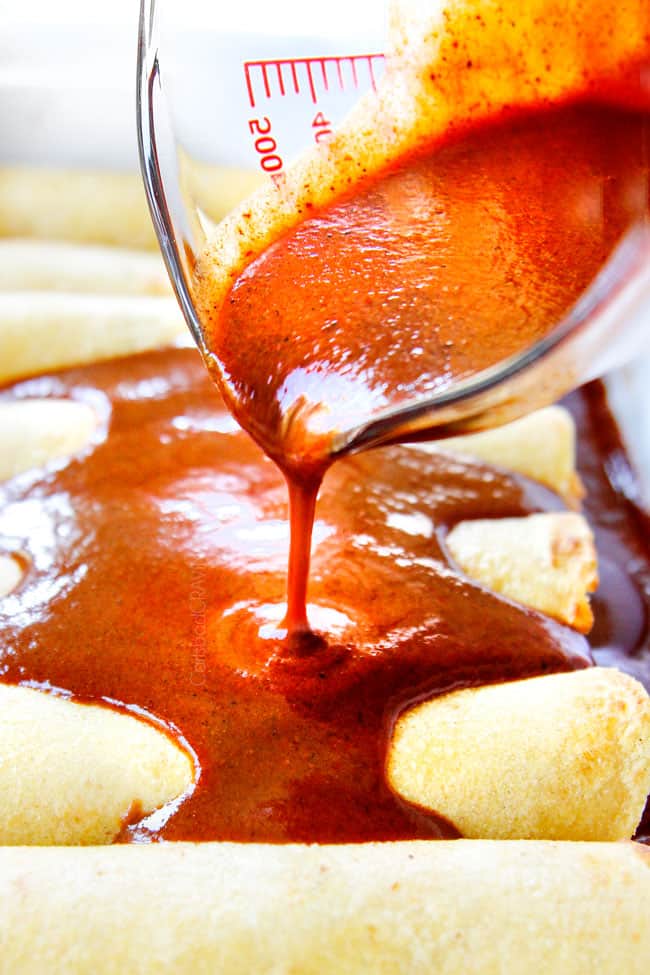 showing how to make easy chicken enchiladas by pouring enchilada sauce over rolled enchiladas