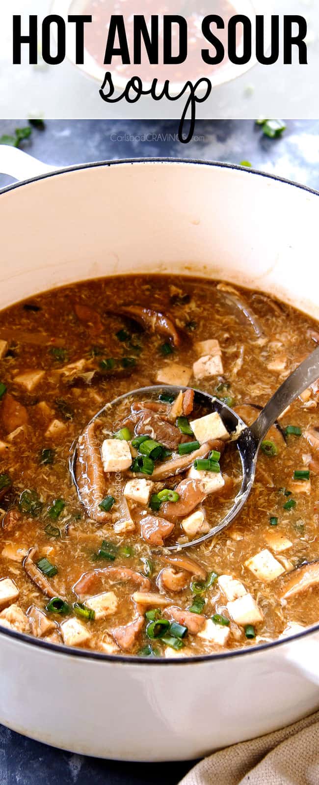 a ladle of Hot and Sour Soup scooping up soup in a large Dutch oven