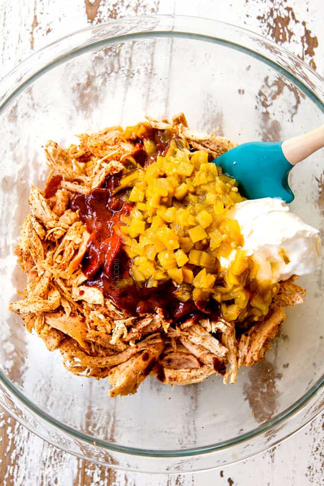 showing how to make chicken enchiladas by adding shredded chicken, seasonings, green chilies, enchilada sauce and sour cream to a glass bowl