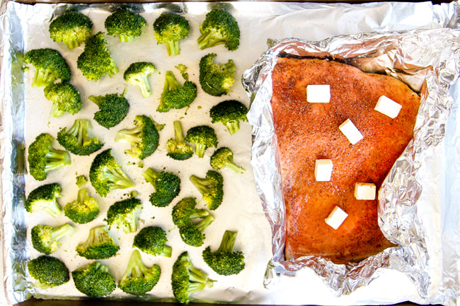 showing how to make salmon pasta by placing salmon and broccoli next to each other on a baking sheet