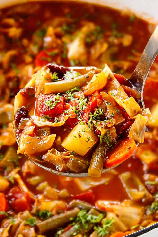 showing how to serve easy Cabbage Soup by garnishing with parsley and Parmesan