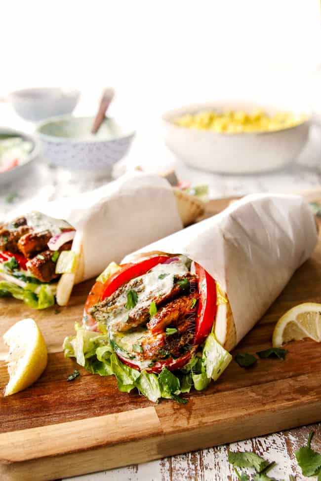 showing how to serve shawarma by drizzling chicken shawarma wraps with yogurt sauce