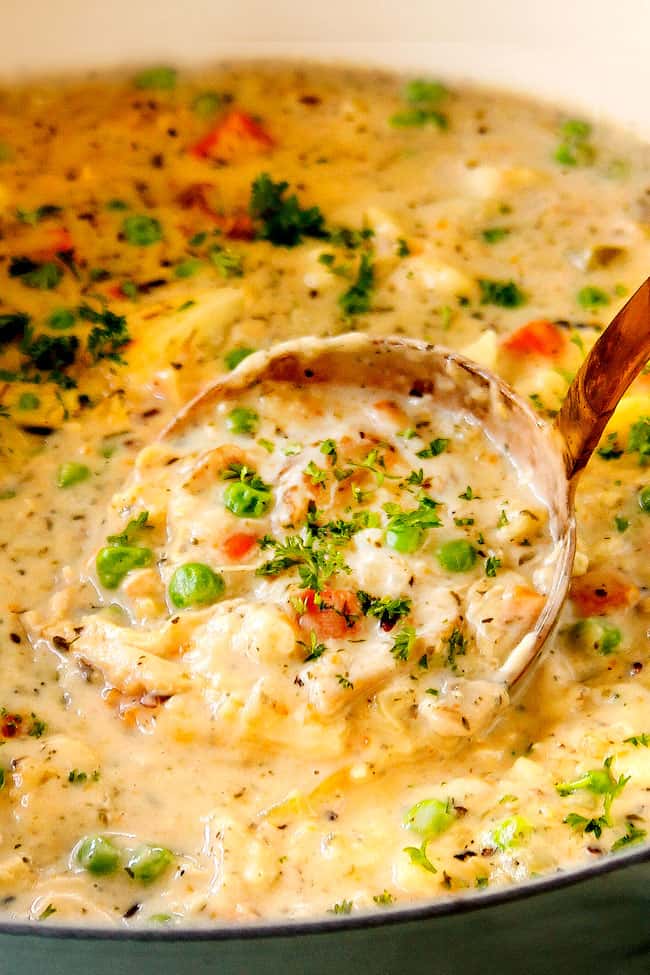 up close of a ladle full of creamy chicken and rice soup showing how creamy it is.