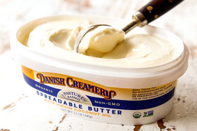 showing how to make lemon butter salmon by scooping butter out to make the sauce