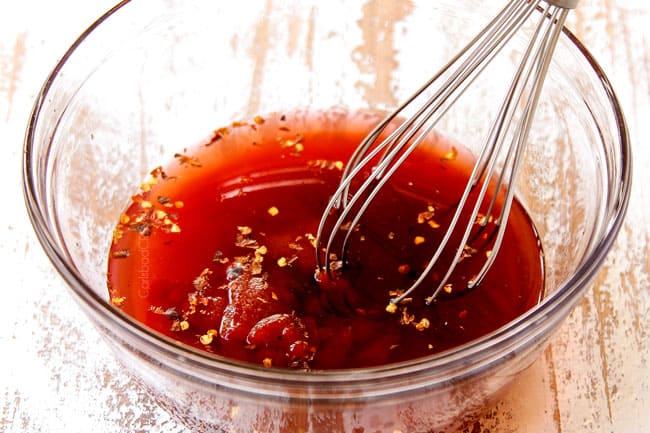 showing how to make sweet and sour chicken by whisking red wine vinegar, sugar, pineapple juice and ketchup together to make sweet and sour sauce