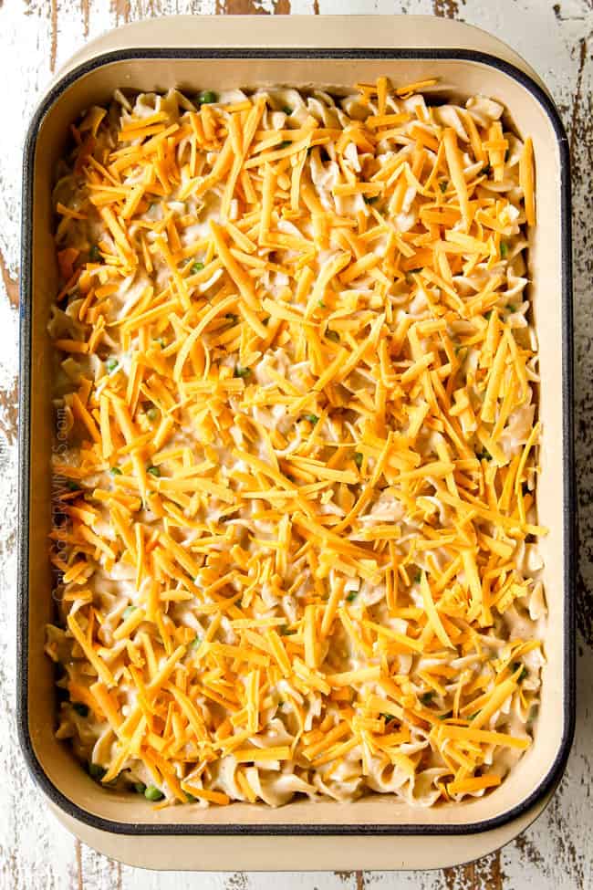 showing how to make Tuna Noodle Casserole by topping 9x13 baking dish with cheese