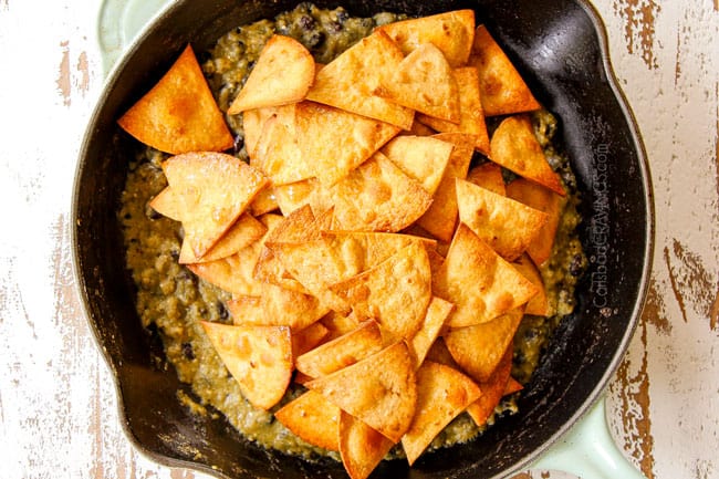 showing how to make Chilaquiles Verdes by adding crispy baked tortilla chips
