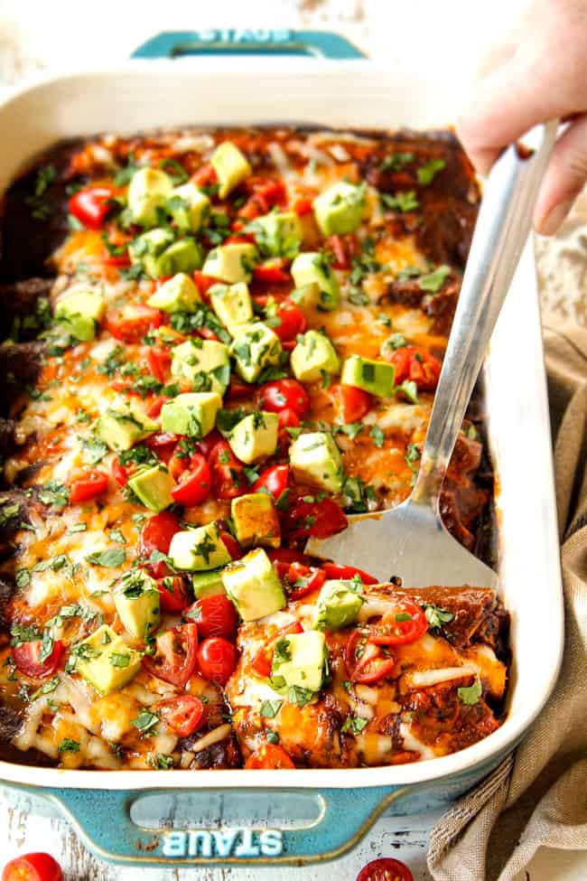 showing how to serve ground beef enchiladas by scooping out a serving with a spatula