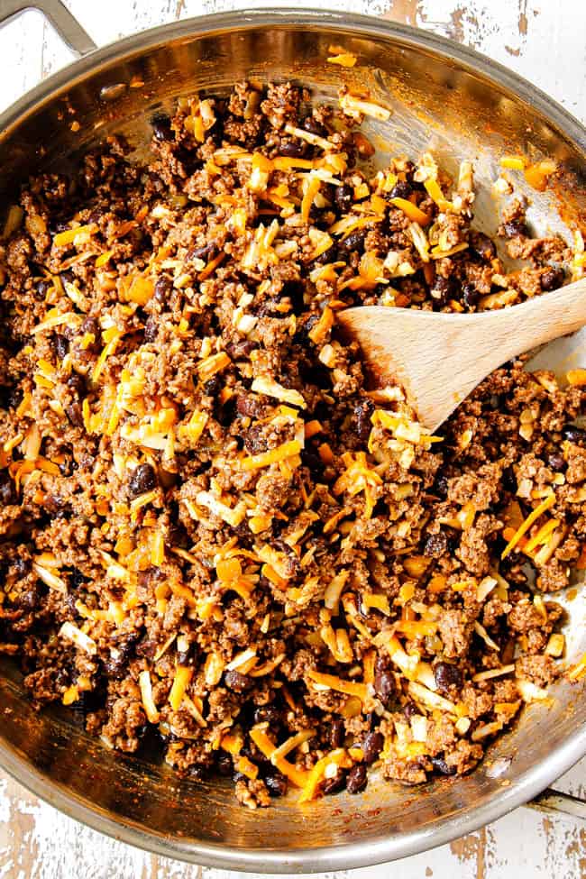 showing how to make ground beef enchiladas by stirring cheeses into ground beef