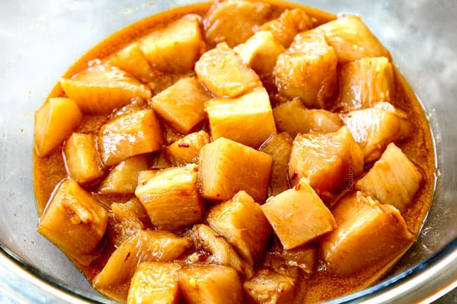 showing how to make Chinese Chicken and Broccoli by marinating chicken in a glass bowl