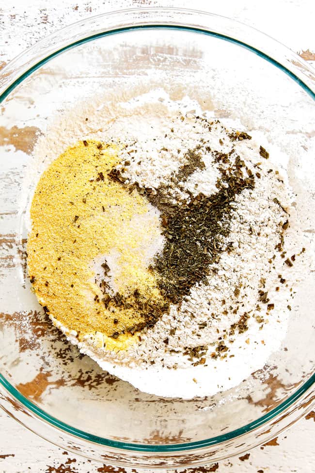 showing how to make best chicken and dumplings recipe by whisking flour, cornmeal, baking powder together in a glass bowl