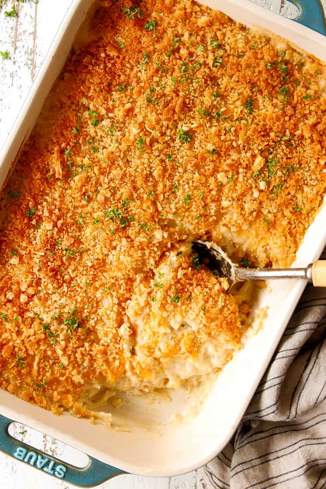 showing how to top easy hashbrown casserole by topping with crushed Ritz crackers