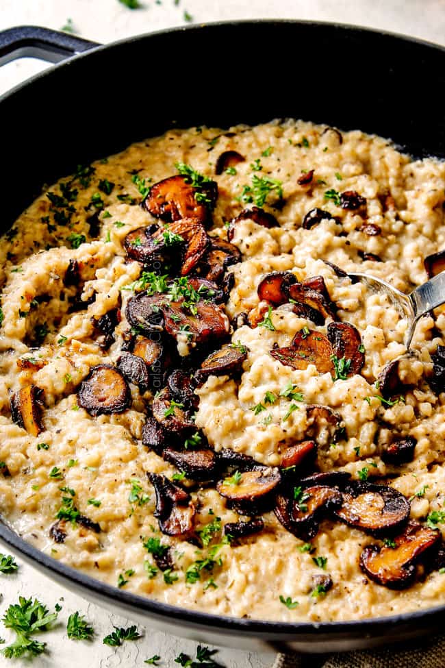 showing how to serve mushroom risotto recipe by scooping up risotto with a silver spoon