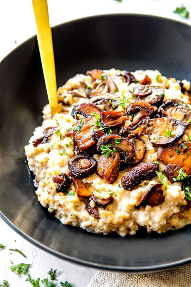 a bowl of easy mushroom risotto recipe garnished with mushrooms showing how deeply caramelized the mushrooms should look