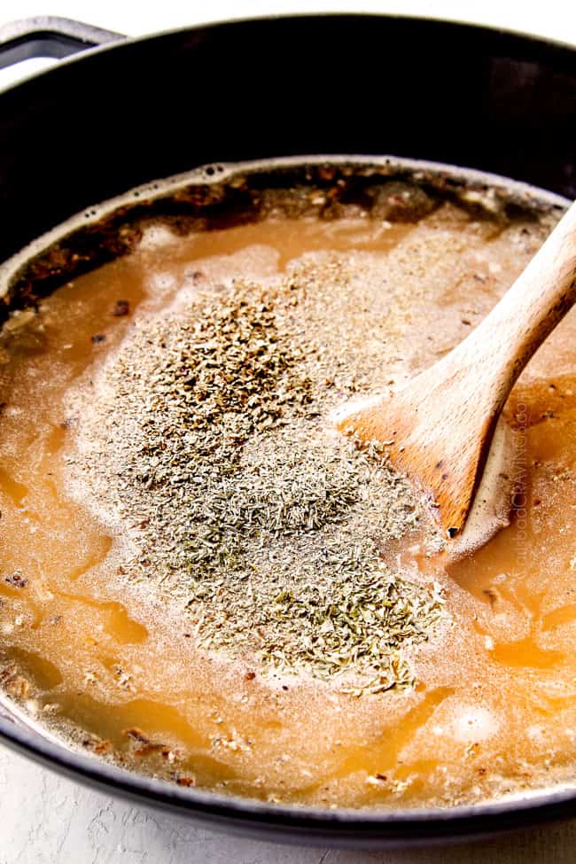 showing how to make mushroom risotto recipe by adding warm broth, salt, pepper, parsley, thyme to rice in black Dutch oven