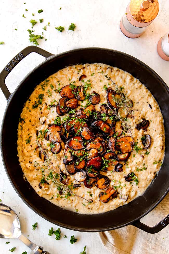 top view of mushroom risotto showing how to garnish with caramelized mushrooms, fresh thyme and fresh parsley