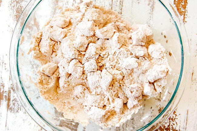 showing how make Popcorn Chicken recipe by adding marinated chicken to flour breading