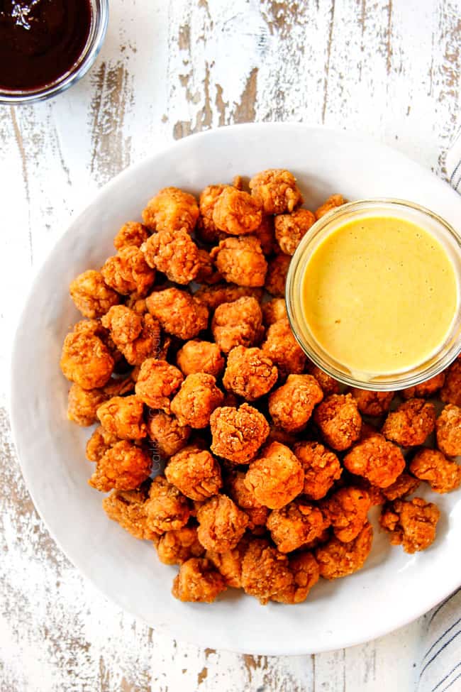 showing how to serve KFC Popcorn Chicken by placing on a white platter with honey mustard dip