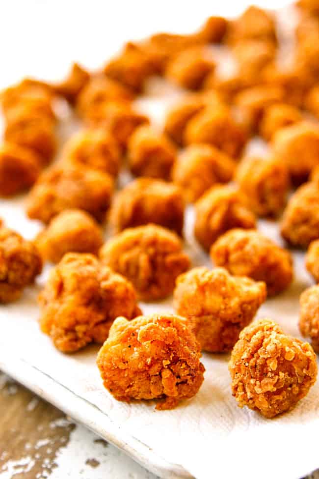 showing how to make Popcorn Chicken by draining chicken on paper towels in a single layer