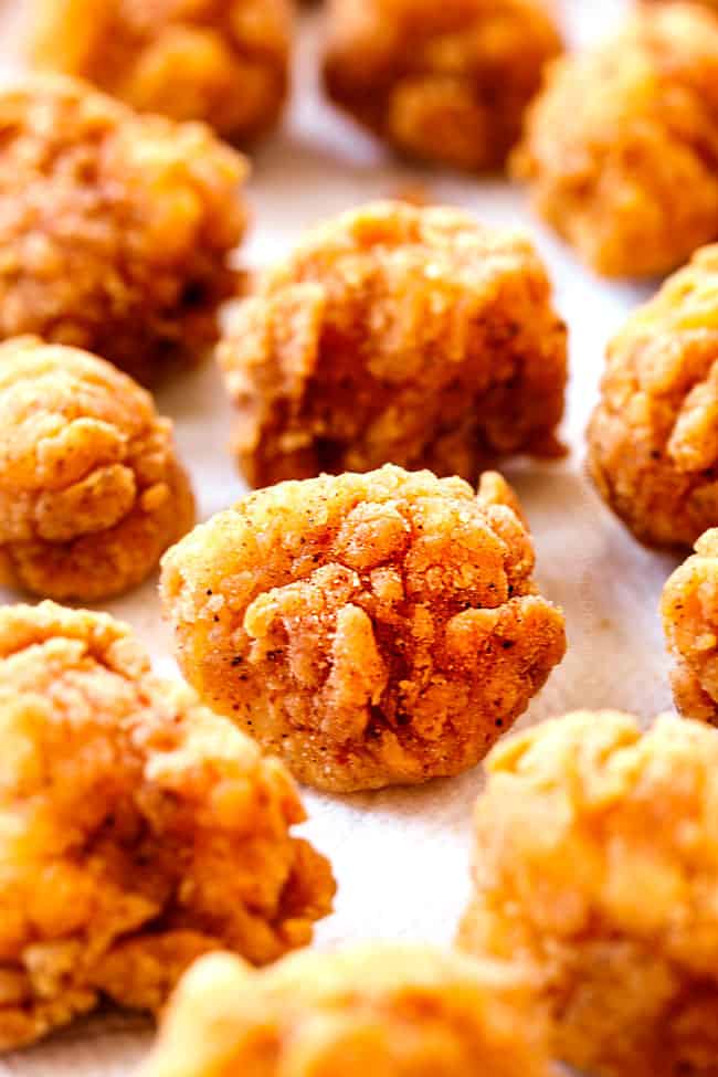 showing how to make Popcorn Chicken recipe by lining chicken pieces in a single layer on paper towels to drain off grease