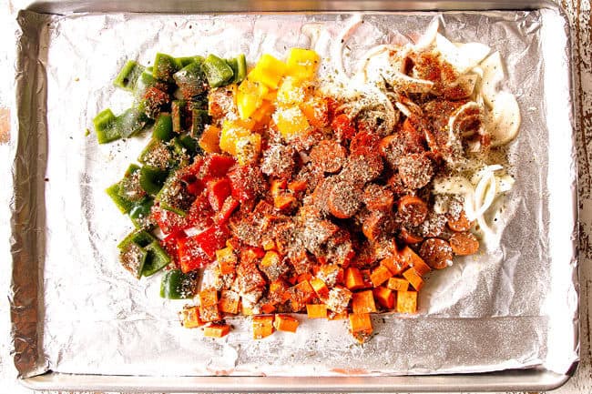 showing how to make baked Sausage and Peppers by tossing sausage, peppers and onions with olive oil and Italian seasonings