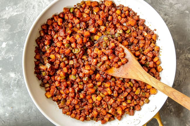 showing how to make breakfast tacos by adding chorizo to potatoes and cooking in a skillet