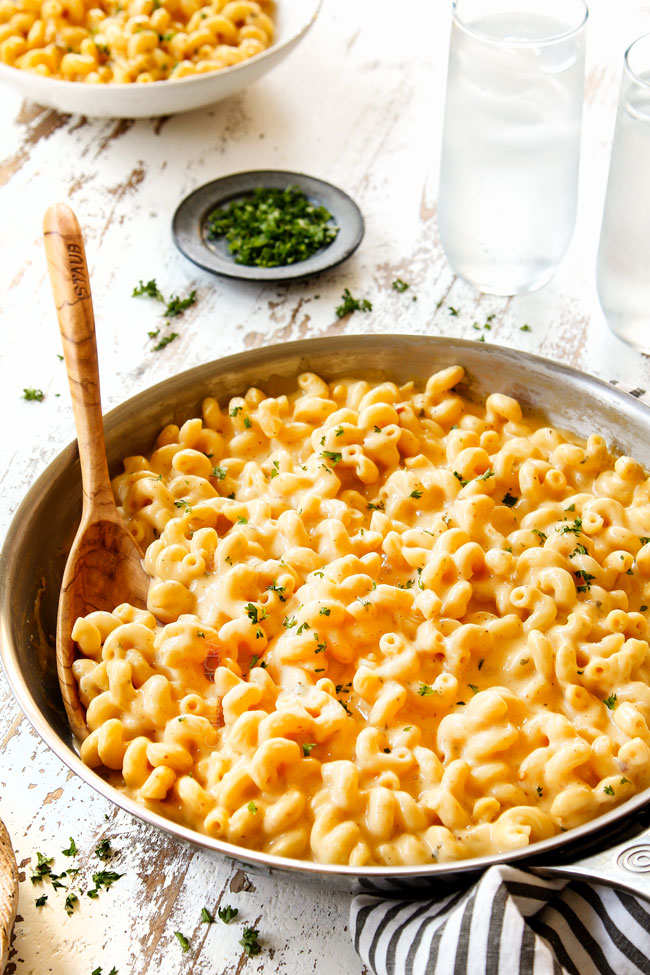 showing how to make homemade mac and cheese recipe by stirring cheeses until smooth