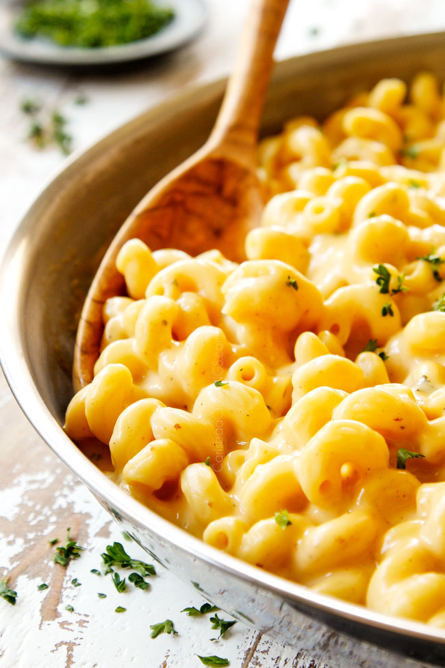 showing how to make best mac and cheese by stirring pasta into cheese sauce until combined