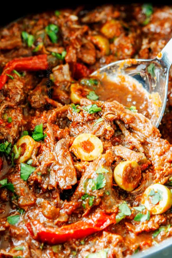 showing how to make Ropa Vieja recipe by stirring cilantro into the slow cooker