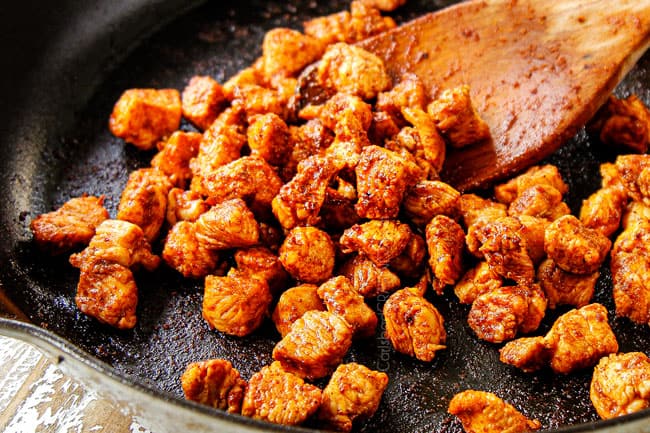 showing how to make BBQ Chicken Pizza recipe by cooking chicken in a cast iron skillet