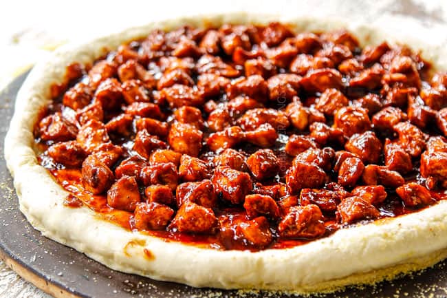 showing how to make BBQ Chicken Pizza recipe by topping pizza dough with BBQ chicken