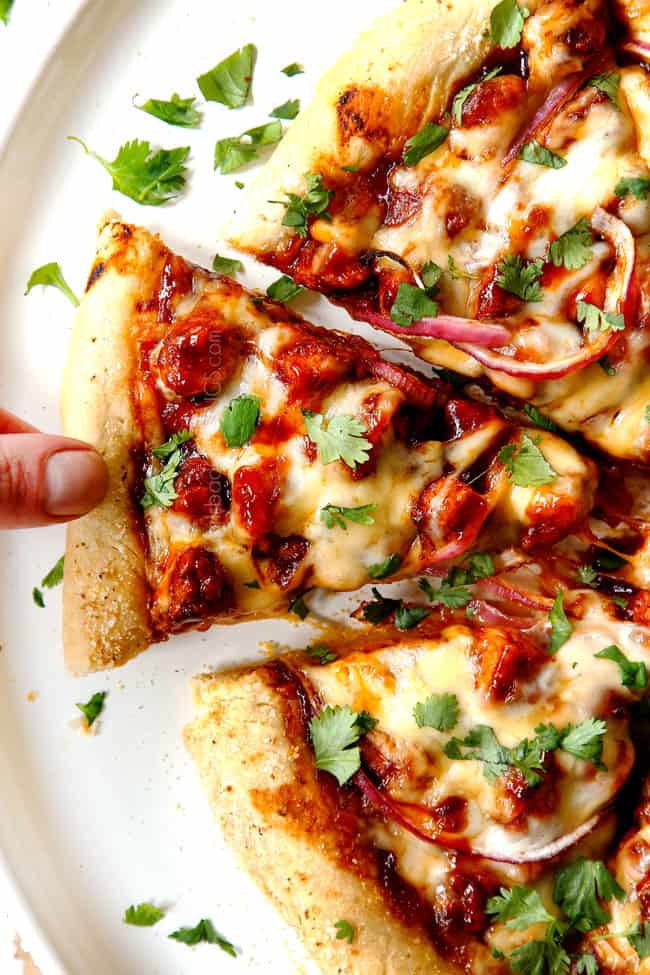 showing how to serve BBQ Chicken Pizza recipe by picking up a slice of pizza