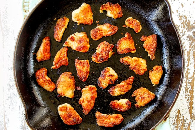 showing how to make Hunan chicken by adding lightly breaded chicken to a cast iron skillet