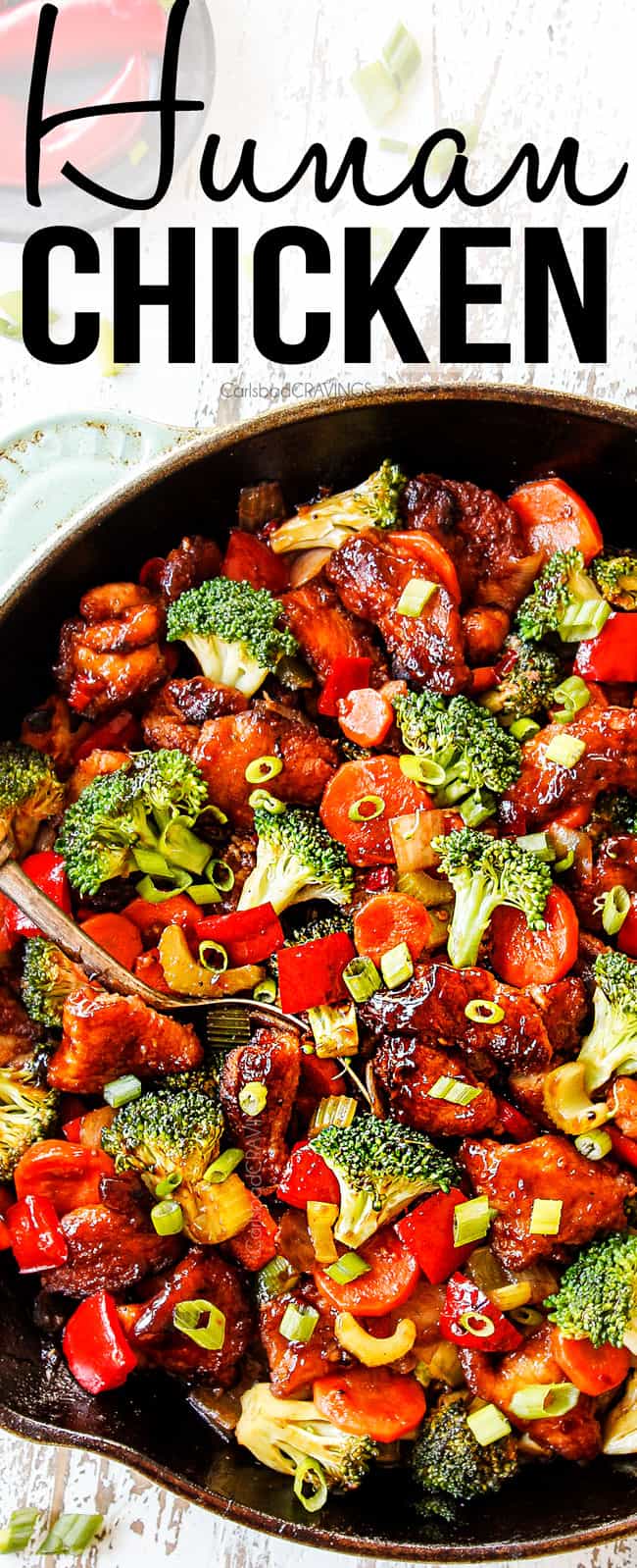 showing how to serve Hunan Chicken by garnishing with green onions in a large cast iron skillet