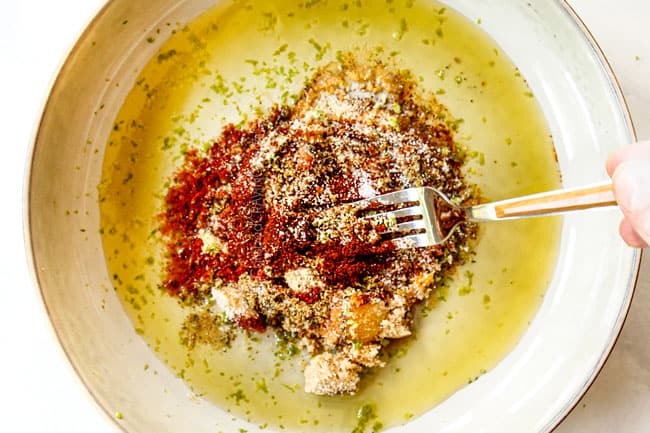 showing how to make mango salad with chicken by adding olive oil, chili powder, smoked paprika, garlic powder, onion powder, lime juice and lime zest to a bowl