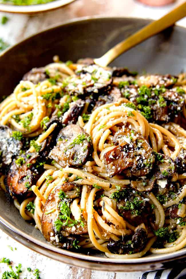 showing how creamy Mushroom Pasta is with an up close shot of pasta in a grey bowl.