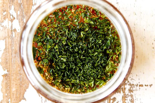 showing how to make orzo pasta salad by combining olive oil, red wine vinegar, lemon juice and fresh herbs in a glass jar